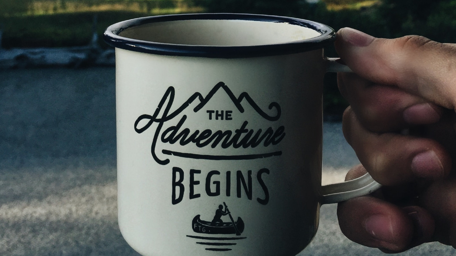 Cup bearing the label "The adventure begins"